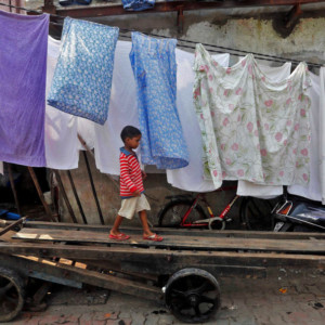 Children play on a hand cart inside a slum in Mumbai